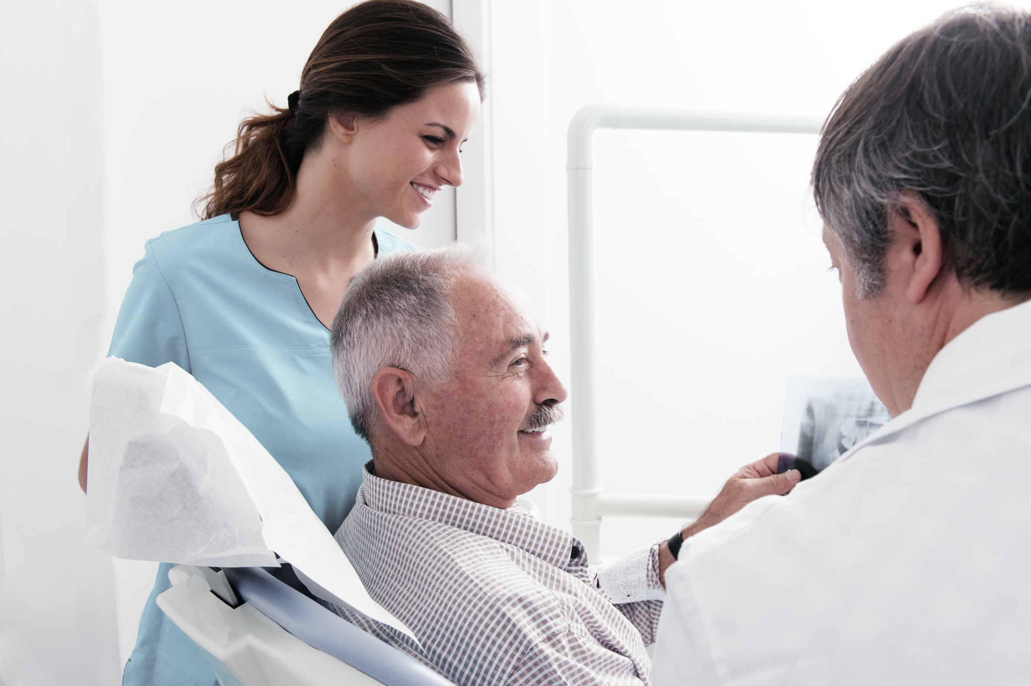 Senior citizen discussing his X-days with dentist
